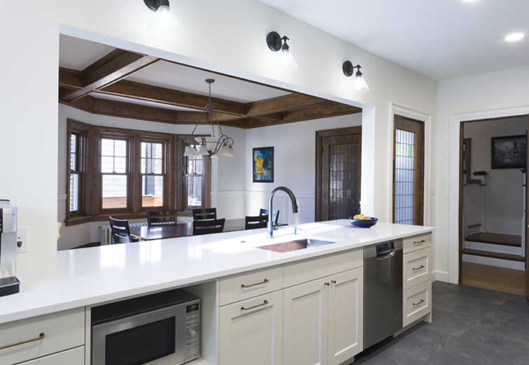 A kitchen with white cabinets and a large island.